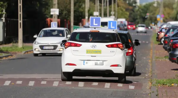Samochody nauki jazdy z literą "L" na dachu i tabliczką "EGZAMIN" na tylnej klapie, kategoria a.