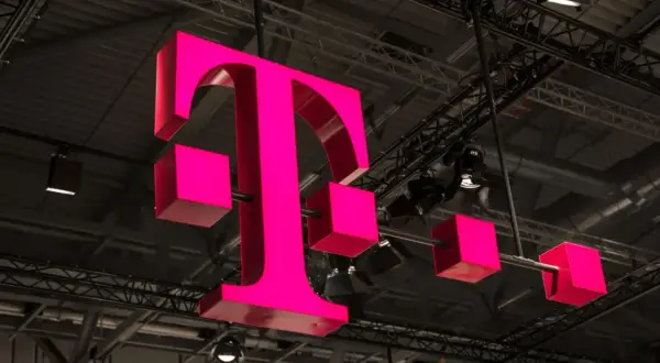 Trójwymiarowe, różowe logo T-Mobile zawieszone pod sufitem hali.