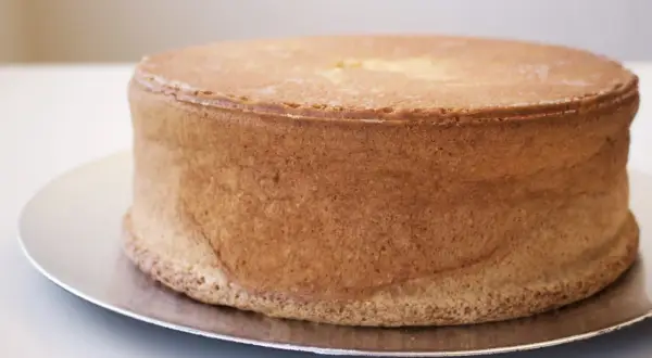 En gyllene tårtbotten, perfekt för ett tårtbotten recept 3 delar. Den ser fluffig och redo att dekoreras ut.