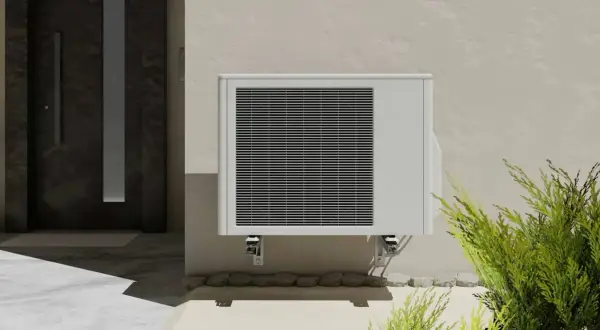Unité extérieure de clim 2,5 kW, idéale pour une surface de 25 à 35 m². Installée près d'une porte d'entrée moderne.