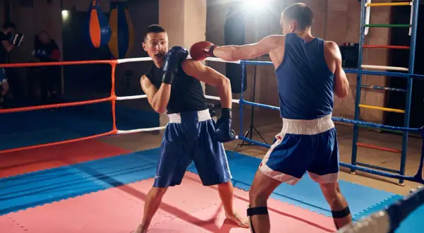 Two boxers spar in a ring, demonstrating how to fight boxing with jabs and defensive moves.
