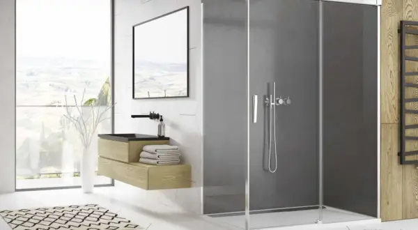 Salle de bain moderne avec paroi de douche en plexiglas fumé, meuble vasque en bois, et vue panoramique.