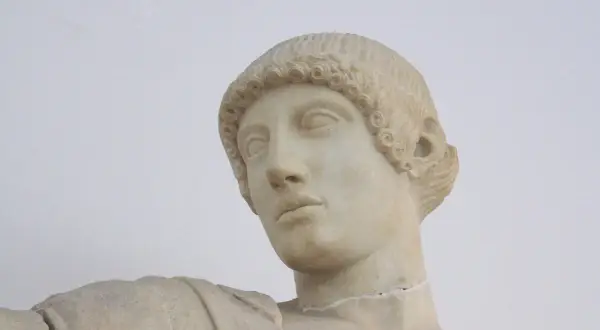 Buste en marbre d'Apollon, dieu grec ou romain, aux boucles caractéristiques et au regard pensif.
