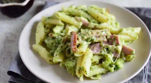 Penne z brokułami i kawałkami szynki w kremowym sosie śmietanowym, posypane serem. Pyszne danie, które zachwyci każdego.
