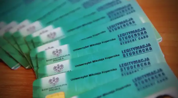 Stos zielonych legitymacji studenckich Uniwersytetu Mikołaja Kopernika.