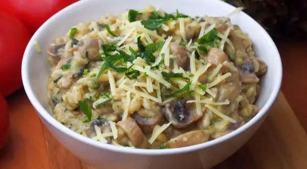 Aksamitne risotto z pieczarkami, posypane startym serem i świeżą natką pietruszki. Idealne na jesienny obiad.