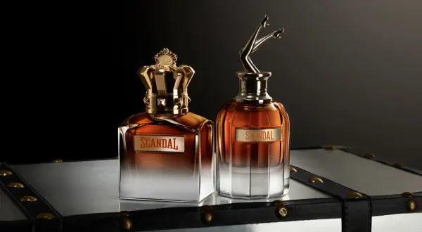 Dwa flakony perfum Jean Paul Gaultier Scandal Meski: jeden z koroną, drugi z nogami w szpilkach.