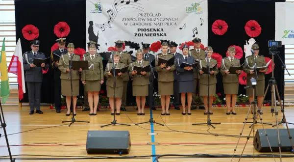 Chór żołnierski śpiewa pieśni patriotyczne. Wojenko, wojenko, tekst tej piosenki rozbrzmiewa na przeglądzie w Grabowie.