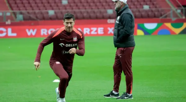 Robert Lewandowski, który ma najwięcej występów w reprezentacji Polski, podczas treningu. Obok niego stoi trener.