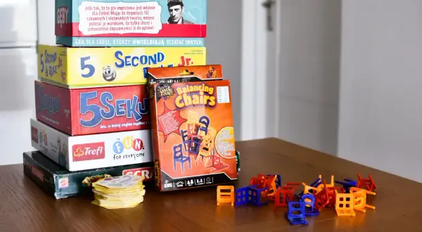Stos pudełek z popularnymi grami dla dzieci: "5 Sekund", "Balancing Chairs", "Scrabble" i inne. Idealne na rodzinne wieczory.