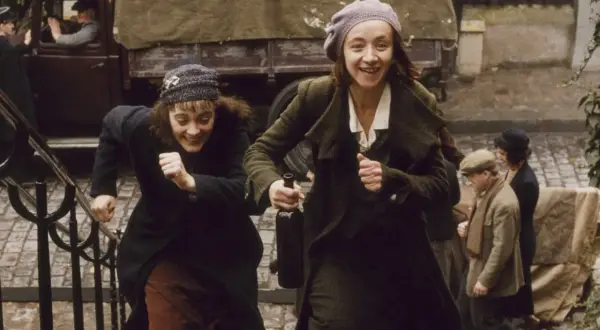 Dwie kobiety biegną po schodach, śmiejąc się radośnie. Jedna z nich trzyma butelkę wina. Bohaterka filmu niczego nie żałuje, ciesząc się chwilą.