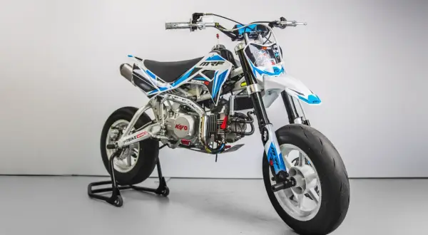 Biało-niebieski pit bike MRF Supermoto 140 na stojaku, z widocznym silnikiem Kayo.