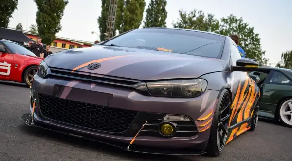 Zmodyfikowany Volkswagen Scirocco z nakładkami na błotniki w płomienie i pasy.