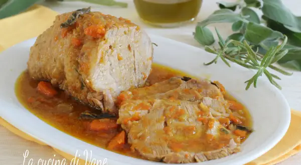 Succulento arrosto di vitello al forno, affettato e servito in un sughetto saporito con carote e erbe aromatiche.