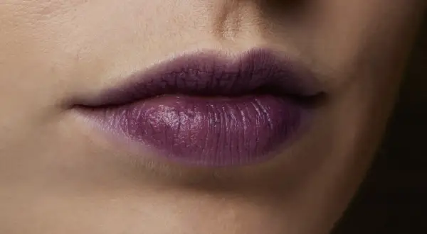 Labbra con rossetto viola intenso, un colore audace che dona a chi osa sperimentare.
