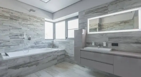 Modernos baños con bañera, lavabo y espejo iluminado. Inspiración para tus ideas baños.