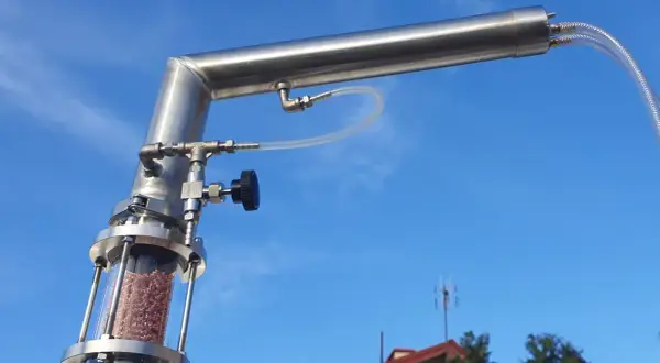 Metalowy destylator z wypełnieniem w szklanej kolumnie, gotowy do pracy. To właśnie destylator pozwala na oczyszczanie substancji.