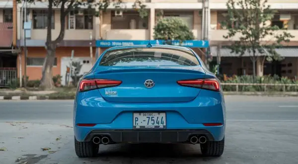 Vue arrière d'une voiture bleue. Le **code couleur voiture carte grise** est bien visible sur la plaque d'immatriculation.