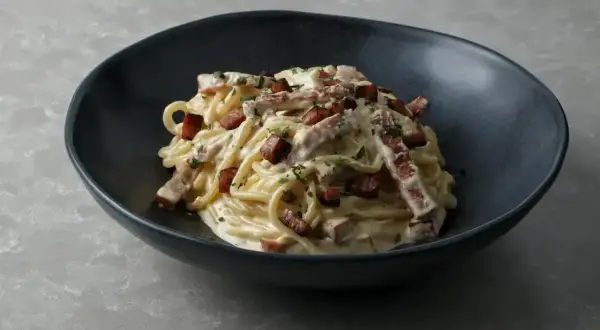 Pyszne spaghetti carbonara z chrupiącym boczkiem i parmezanem. Idealne carbonara skladniki.