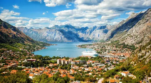 Bucht von Kotor, Montenegro: rote Dächer, Berge, Kreuzfahrtschiff. Entdecken Sie Montenegro Geheimtipps in dieser malerischen Kulisse.