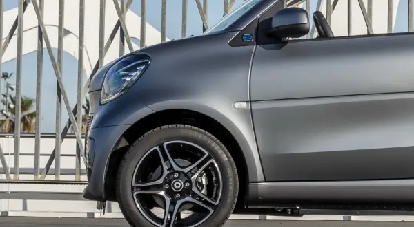 Smart EQ fortwo con vernice opaca auto grigio scuro, dettaglio del parafango anteriore e cerchio in lega.