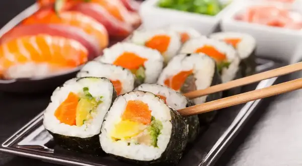 Pyszne rolki sushi z łososiem i warzywami, idealne po tym, jak nauczysz się, jak ugotować ryż do sushi.