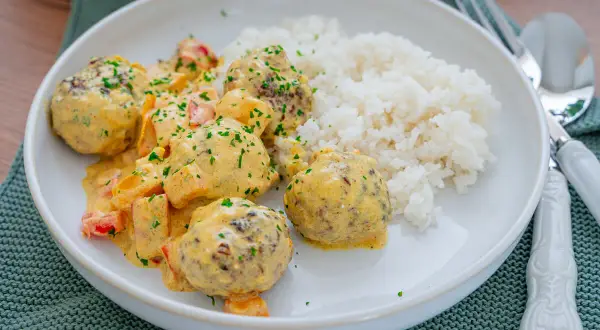 Fleischbällchen in cremiger Sauce mit Paprika und Reis. Ein Gericht, das zeigt, dass reis noch hart sein kann, wenn er nicht richtig gekocht wird.