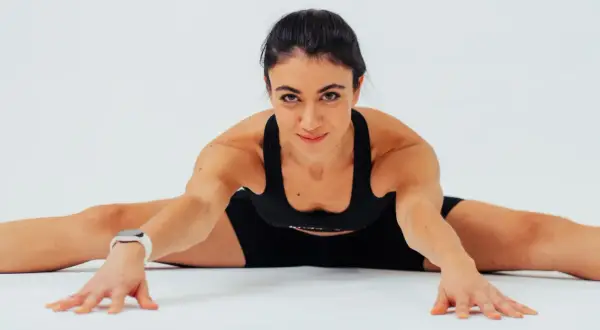 Donna in posa di stretching, ideale per capire quante volte a settimana fare pilates per migliorare flessibilità e forza.