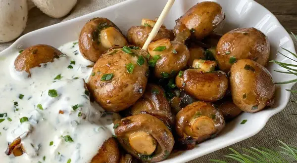 Gebratene Champignons mit cremiger Sauce und Schnittlauch – ein einfaches Gericht, das zu vielen Champignons Rezepten passt.