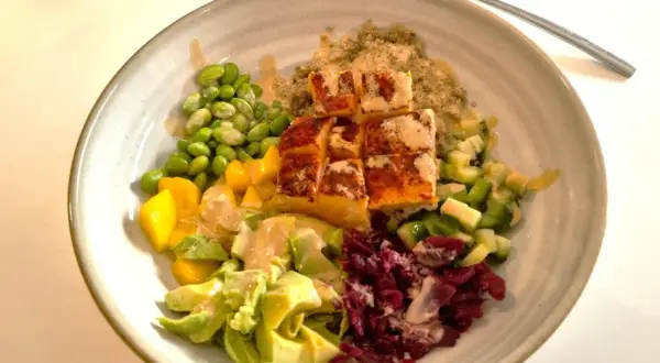 En färgstark bowl med lax, quinoa, edamamebönor, mango, avokado och rödbetor. Ett perfekt mat tips för en hälsosam lunch.