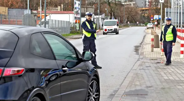 Policjant zatrzymuje czarne auto, być może kolejny mandat dla recydywisty.
