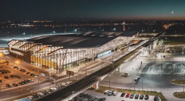 Nowoczesny terminal lotniska w Gdańsku nocą. Widok z góry pokazuje parkingi, drogi i tory kolejowe, ułatwiając planowanie, jak dojechać na lotnisko w Gdańsku.