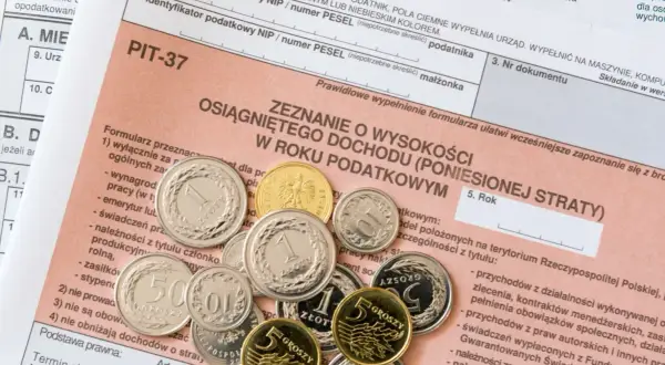 Złote monety na formularzu PIT-37. Czy zasiłek dla bezrobotnych jest opodatkowany? To pytanie, na które odpowiedź znajdziesz w zeznaniu podatkowym.