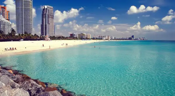 Traumhafter Strand in Miami mit türkisfarbenem Wasser und Wolken am Himmel. Perfekt für Ihre Miami Reisetipps!