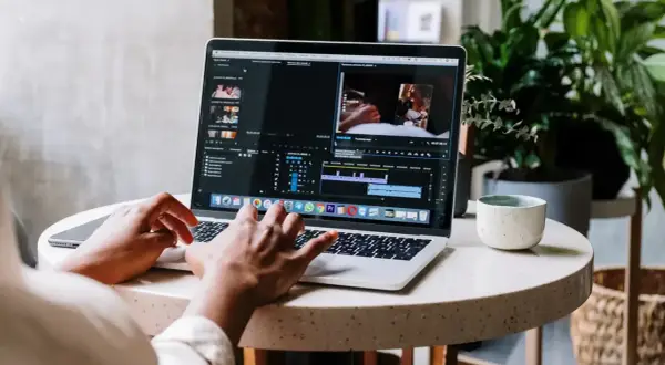 Montażysta filmów pracuje nad projektem na laptopie. Zastanawiasz się, ile zarabia montażysta filmów?