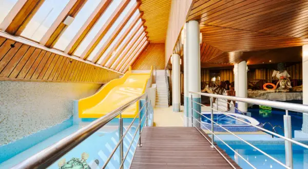 Wodne szaleństwo w hotelu Belvedere Resort & Spa! Żółta zjeżdżalnia wodna i basen z mozaiką żółwi czekają na gości.