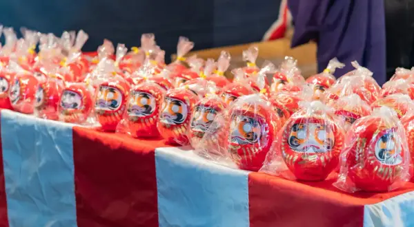 Czerwone lalki Daruma, idealne jako nagroda, gdy zastanawiasz się, co kupić na loterię fantową.