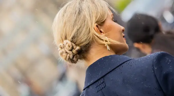 Chignon facile e intrecciato, con orecchini dorati a forma di croce.