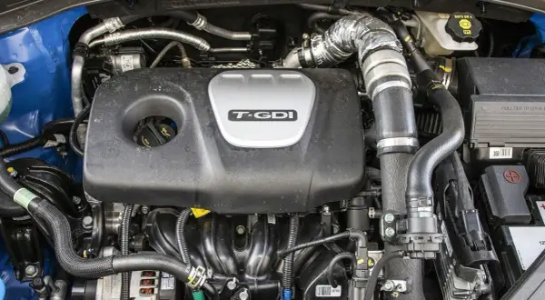 Silnik Kia Sportage 1.6 T-GDI z widocznym turbodoładowaniem i elementami układu dolotowego.