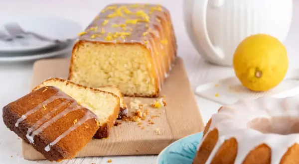 Zitronenkuchen wie bei Oma: saftiger Rührkuchen mit Zuckerguss und frischer Zitrone, daneben ein Gugelhupf.