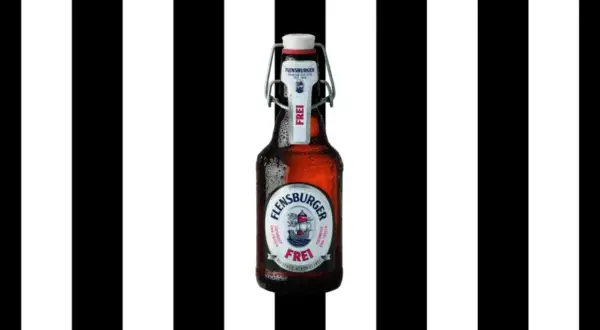 Flasche Flensburger Pilsener Alkoholfrei, mit Bügelverschluss, vor schwarz-weißen Streifen.