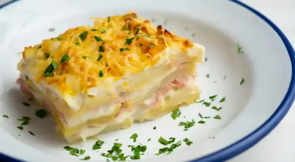 Pyszny kawałek zapiekanki ziemniaczanej z szynką i serem, idealny na obiad. Ten przepis na lasagne ziemniaczaną zachwyci każdego!