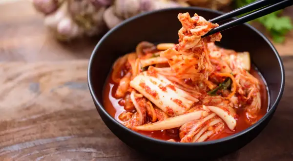 Kimchi jak smakuje? Pikantnie, kwaśno i orzeźwiająco. Kapusta pekińska w intensywnym sosie z chili i czosnkiem, podana pałeczkami.