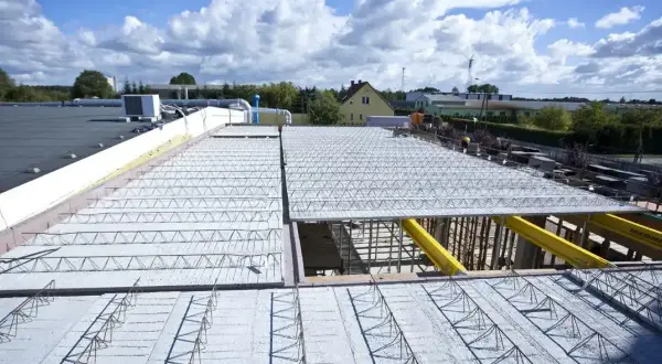 Budowa dachu z prefabrykowanych elementów, ukazująca różne rodzaje stropów w trakcie montażu.