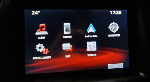Ekran multimediów w Oplu Astrze K. Widoczne ikony: Audio, Telefon, Android Auto, Nawigacja, Ustawienia, SMS, Ruch. Temperatura 24°, godzina 17:29.