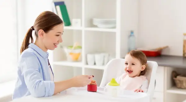 Mama karmi roczne dziecko, które z radością je. To pokazuje, ile powinno jeść roczne dziecko.