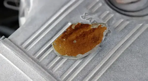 Zardzewiały fragment na metalowej obudowie, przypominający kształtem uszkodzone tłoki silnika.