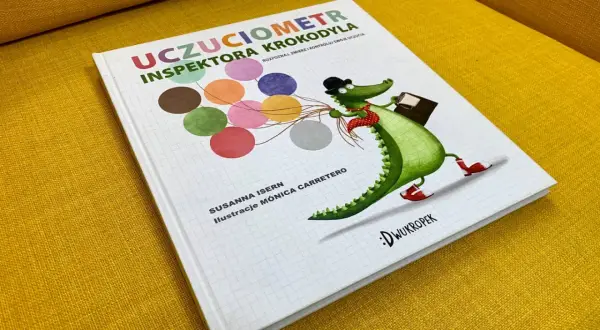 Okładka książki "Uczuciometr Inspektora Krokodyla" z zabawnym, zielonym krokodylem w kapeluszu i z walizką.
