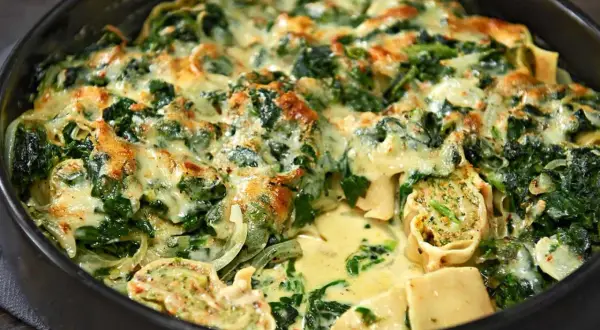 Herzhafter Maultaschen Auflauf mit Spinat und cremiger Käsesauce, goldbraun überbacken.
