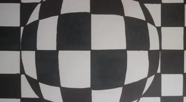 Iluzja 3D w stylu op art. Czarno-biała szachownica zakrzywia się, tworząc wrażenie kuli.